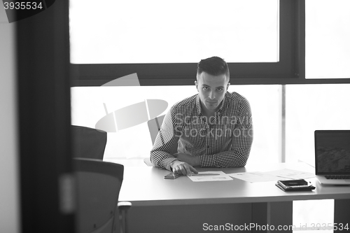 Image of young businessman at his desk in office