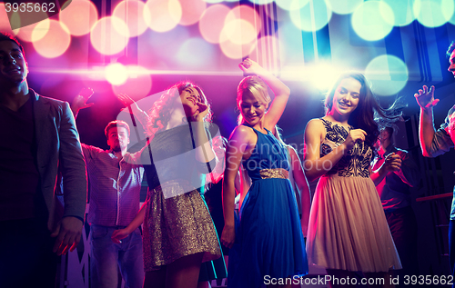 Image of smiling friends dancing in club