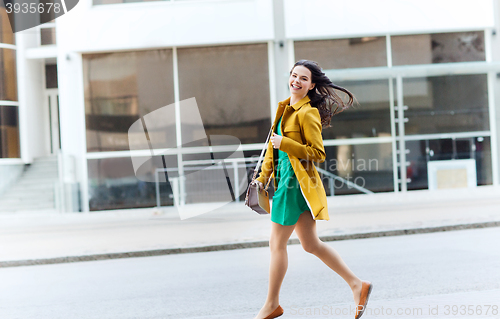 Image of happy young woman or teenage girl on city street