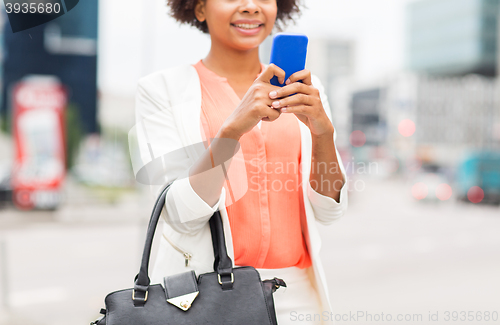 Image of close up of african woman with smartphone in city