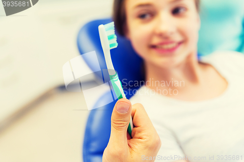 Image of close up of dentist hand with toothbrush and girl