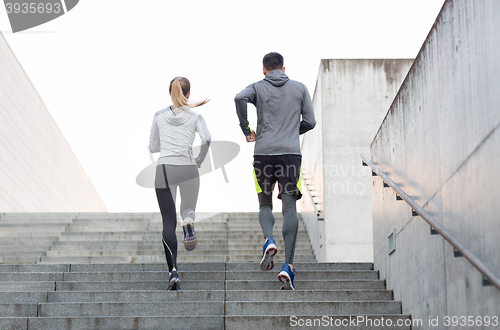 Image of couple running upstairs on city stairs