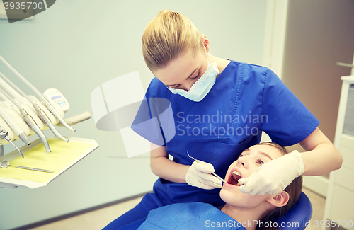 Image of female dentist checking patient girl teeth