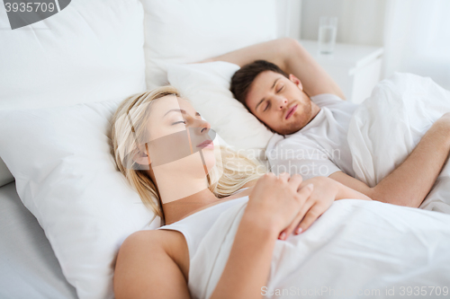 Image of happy couple sleeping in bed at home