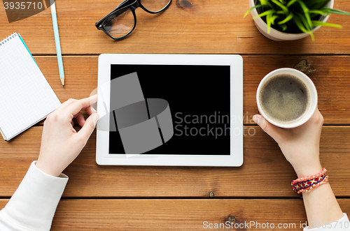 Image of close up of woman with tablet pc on wooden table