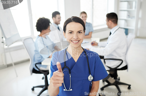 Image of happy doctor over group of medics at hospital