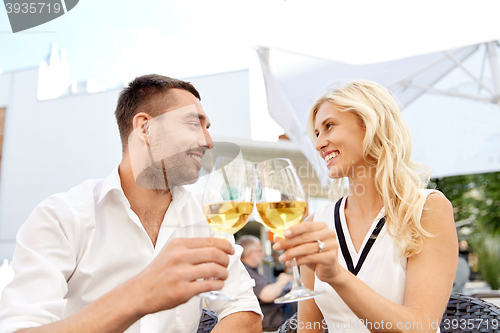 Image of happy couple drinking wine at open-air restaurant