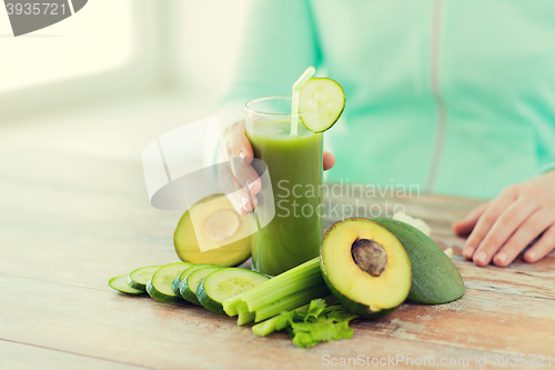 Image of close up of woman hands with juice and vegetables