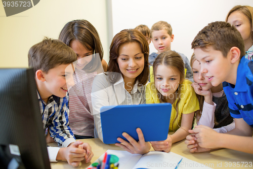 Image of group of kids with teacher and tablet pc at school