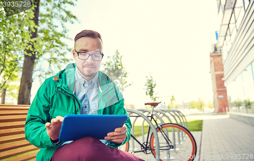 Image of happy young hipster man with tablet pc and bike