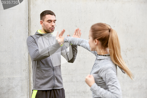 Image of woman with trainer working out self defense strike