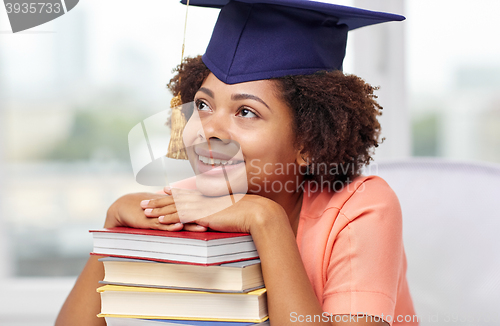 Image of happy african bachelor girl with books at home