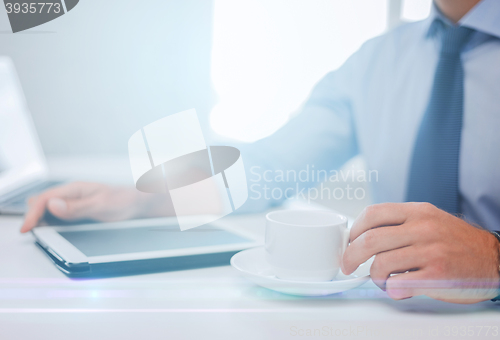 Image of businessman with tablet pc and coffee in office