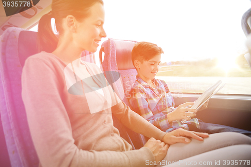Image of happy family with tablet pc sitting in travel bus