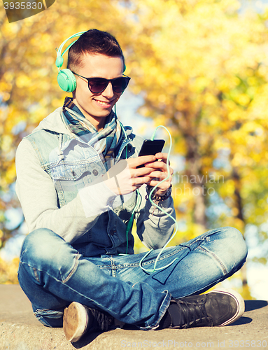 Image of happy young man in headphones with smartphone