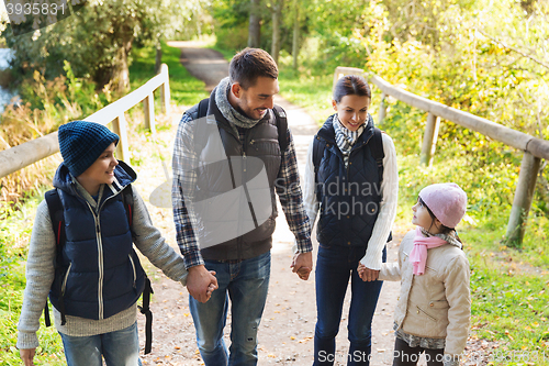 Image of happy family with backpacks hiking in woods