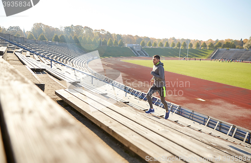 Image of happy young man running upstairs on stadium