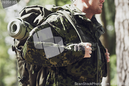 Image of close up of young soldier with backpack in forest