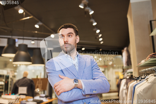 Image of happy young man in jacket at clothing store