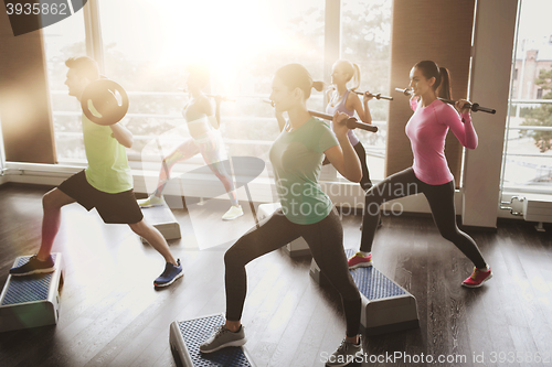 Image of group of people exercising with barbell in gym