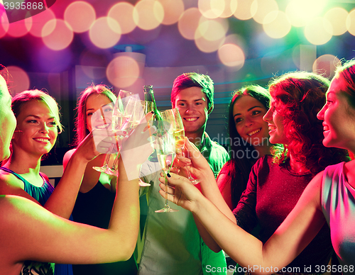 Image of smiling friends with wine glasses and beer in club