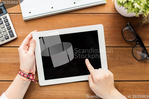 Image of close up of woman with tablet pc on wooden table