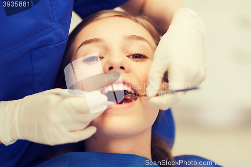 Image of female dentist checking patient girl teeth