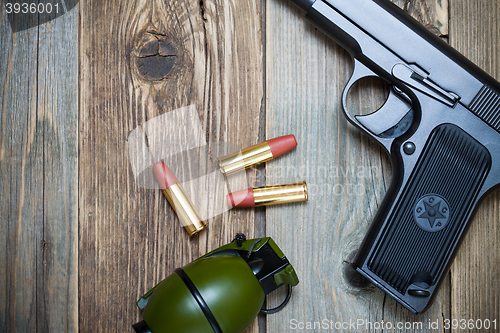 Image of handgun with cartridges and grenade