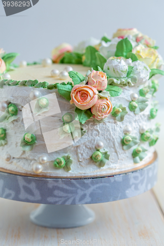 Image of Cake with cream roses and sugar pearls.