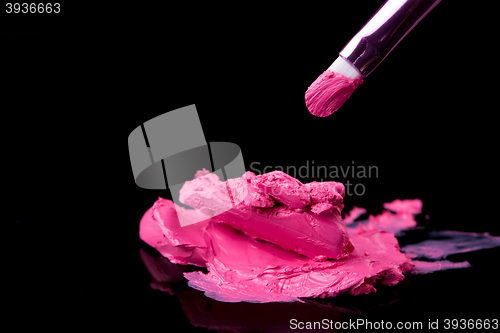 Image of lipstick with a brush make-up on black 