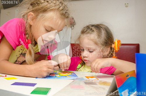 Image of Two girls on the train sitting at the table on the lower second-class place car and enthusiasm make applique