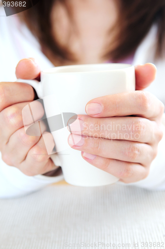 Image of Hands holding a cup