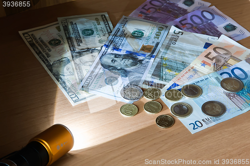 Image of Money in the light beam of the electric torch.