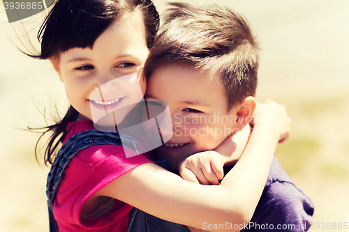 Image of two happy kids hugging outdoors