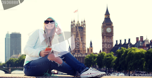 Image of happy young woman with smartphone and headphones