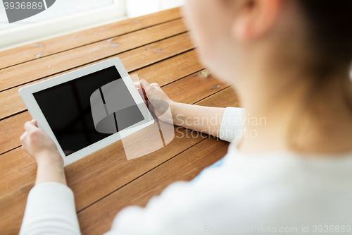 Image of close up of woman with tablet pc on wooden table