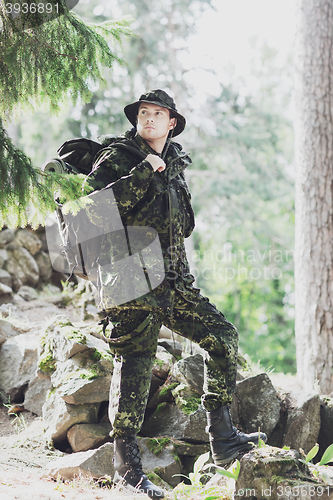 Image of young soldier with backpack in forest