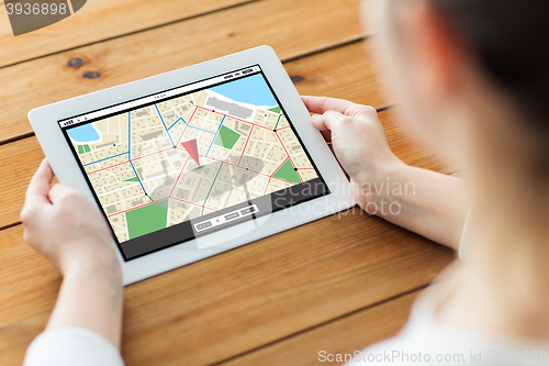 Image of close up of woman with tablet pc on wooden table