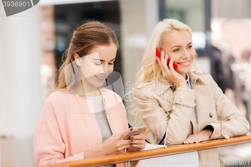 Image of happy women with smartphones and shopping bags