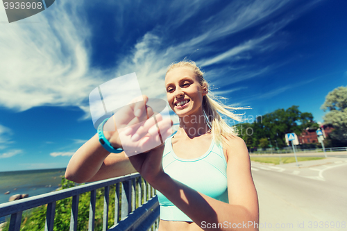 Image of happy woman with heart rate watch and earphones