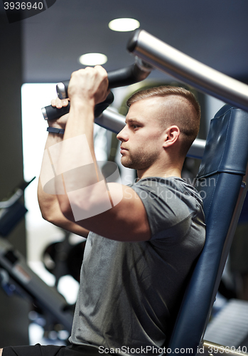 Image of man exercising and flexing muscles on gym machine