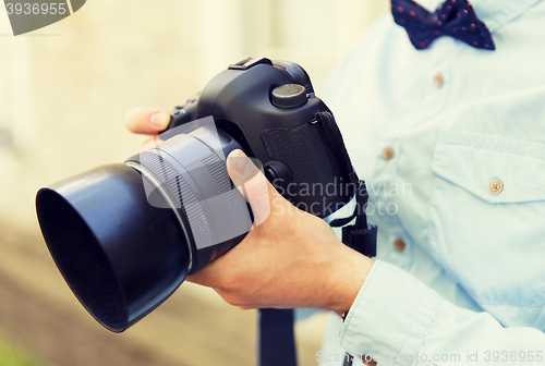 Image of close up of male photographer with digital camera