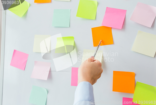 Image of close up of hand pointing to sticker on flip chart