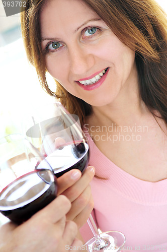 Image of Mature woman toasting with red wine