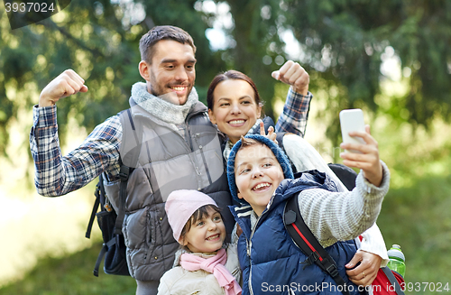 Image of family taking selfie with smartphone in woods