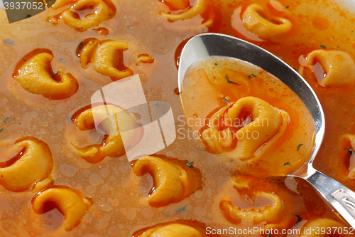 Image of Freshly boiled tortellini in glass bowl with spicy broth