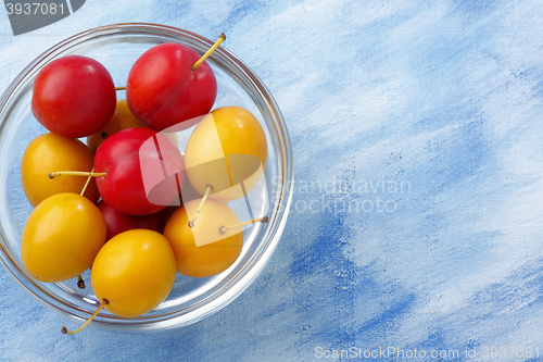 Image of Glass bowl filled by yellow and red mirabelle plums