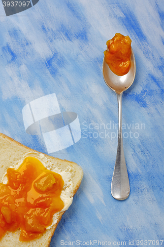 Image of Toast slice with butter and jam and silver spoon with jam blob