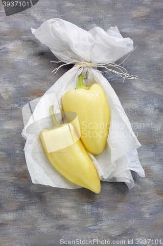 Image of Still life with two yellow peppers and white paper