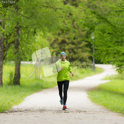 Image of Sporty young female runner in city park.. 